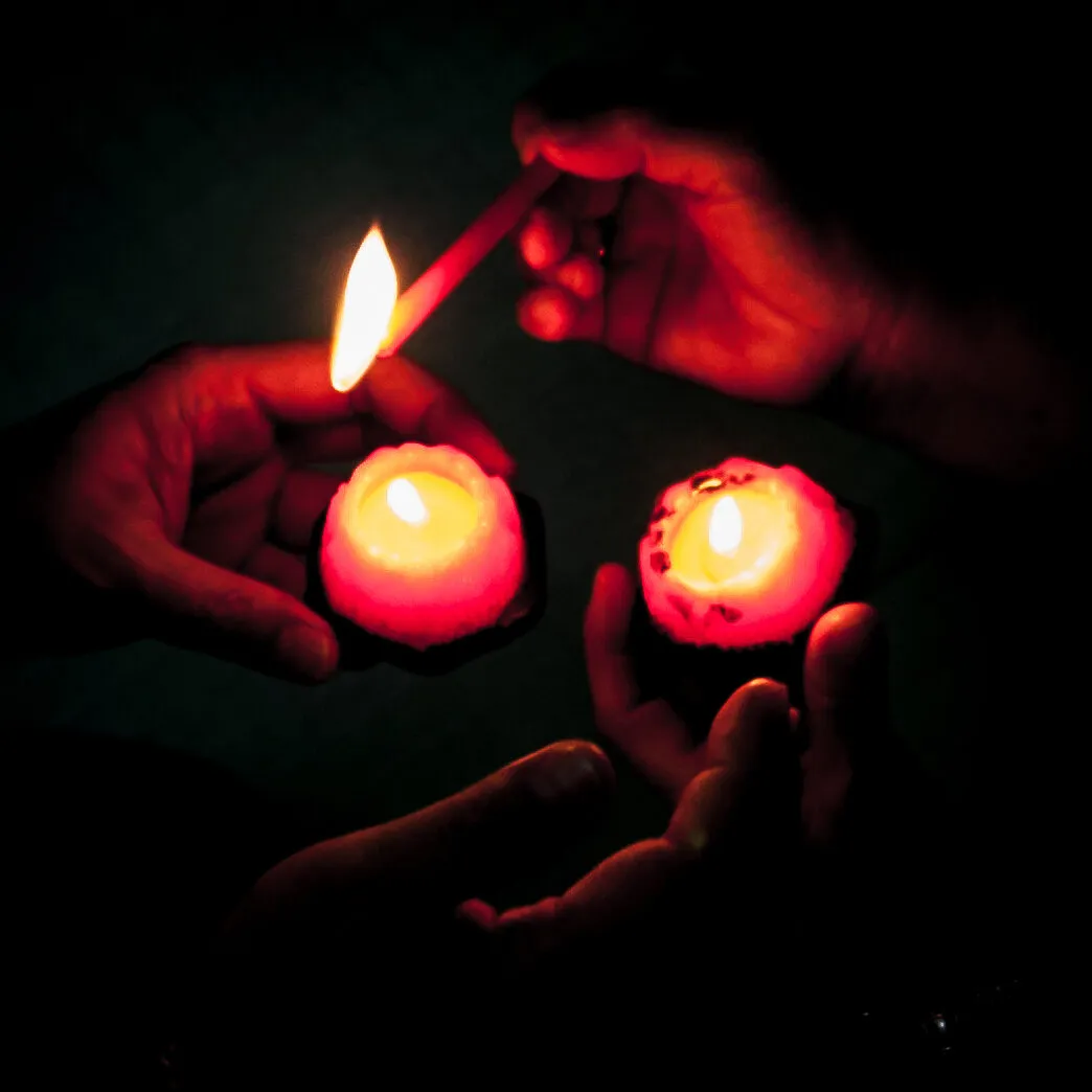 Hands lighting candles